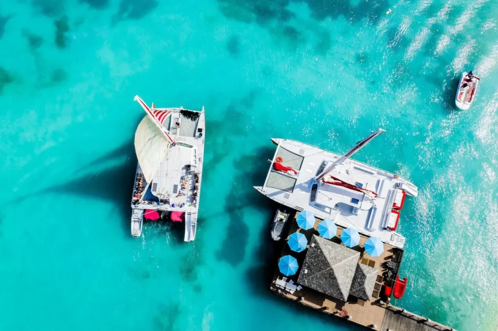 A Red Sail catamaran departing from the dock with passengers on board.