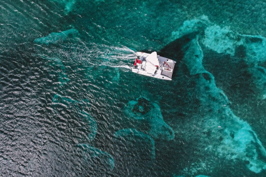 A Red Sail catamaran sailing over turquoise waters.